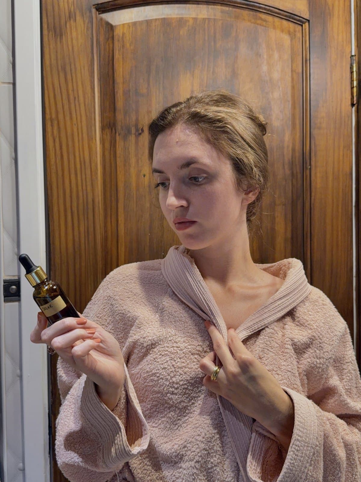 Izabela in a robe with the 50 ml dropper bottle